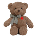 A brown plush teddy bear sitting upright on a white background, wearing a black-and-white gingham bow around its neck and a small red heart patch on the chest.