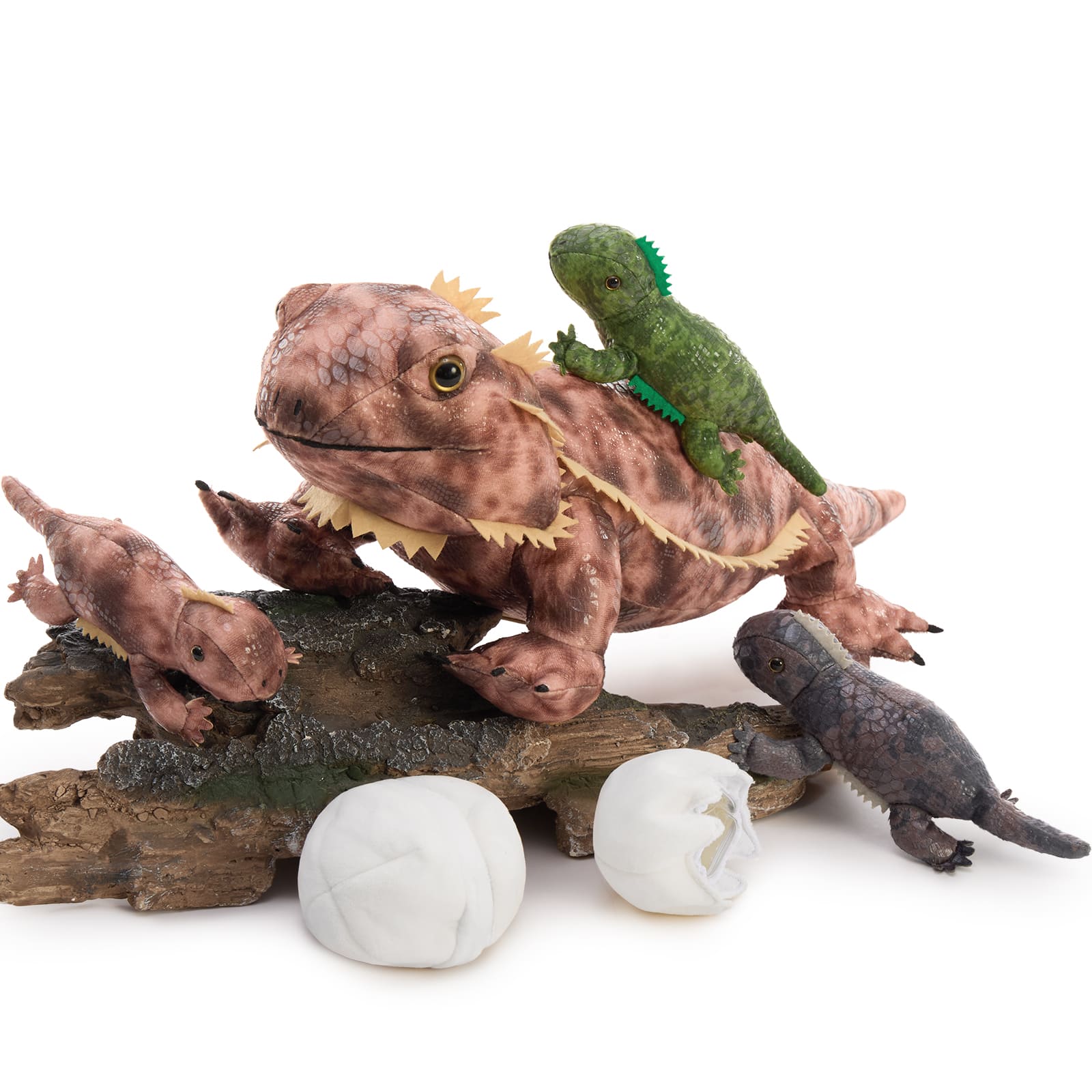 Toy lizards on a branch with eggs on a white background
